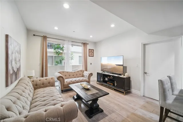 a living room with furniture a flat screen tv and a window