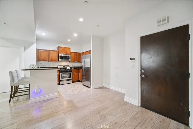 a kitchen with stainless steel appliances granite countertop a refrigerator and a stove top oven