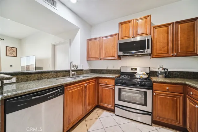 a kitchen with stainless steel appliances granite countertop a sink stove and microwave