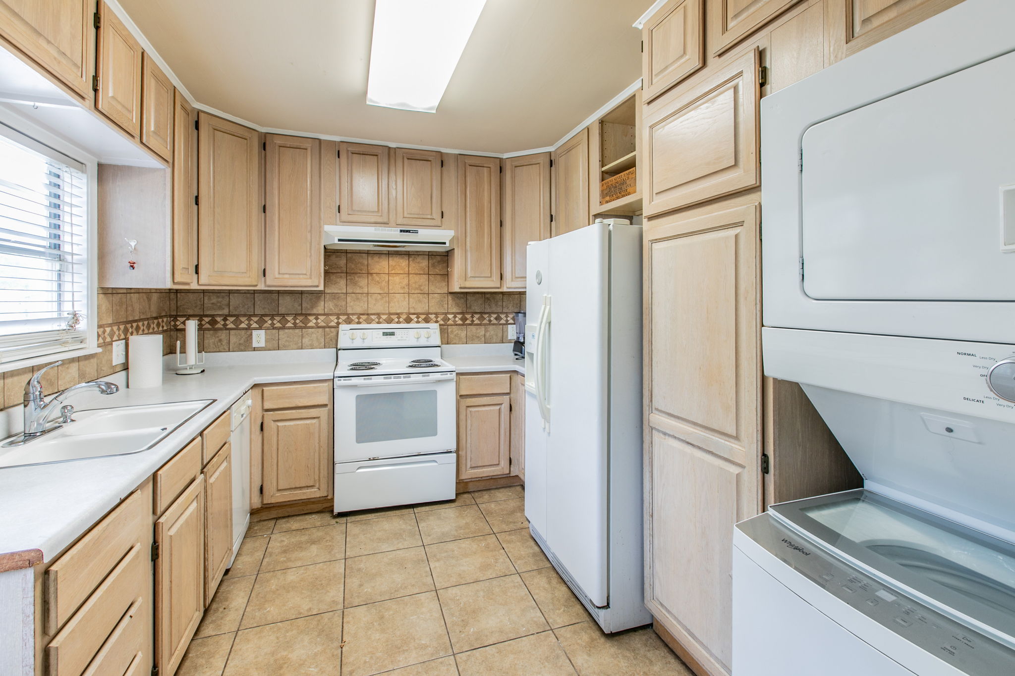 1107 Vargas Road Austin, TX 78741 - Photo 5 of 17 An inviting kitchen features ample cabinetry, a full range of appliances, and convenient in-unit laundry facilities.
