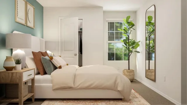 a large white bed sitting in a room next to a lamp