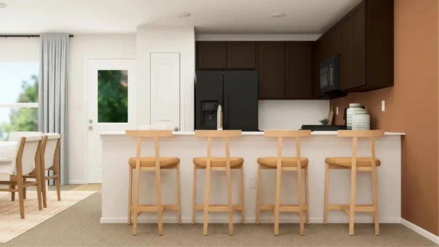a kitchen with white cabinets and chair