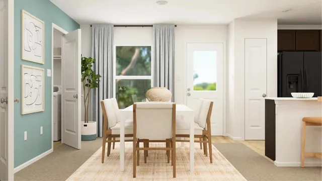 a view of a dining room with furniture a potted plant and a table