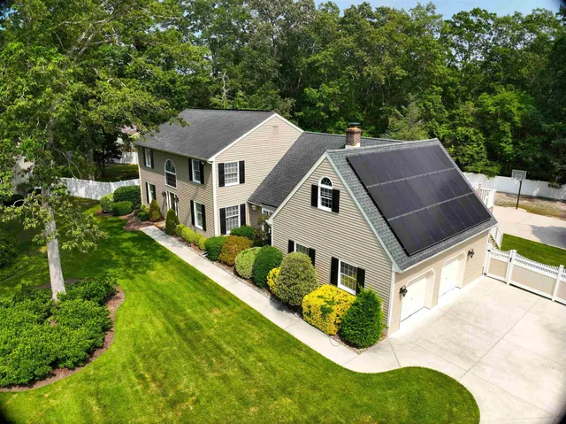 a aerial view of a house with swimming pool next to a big yard