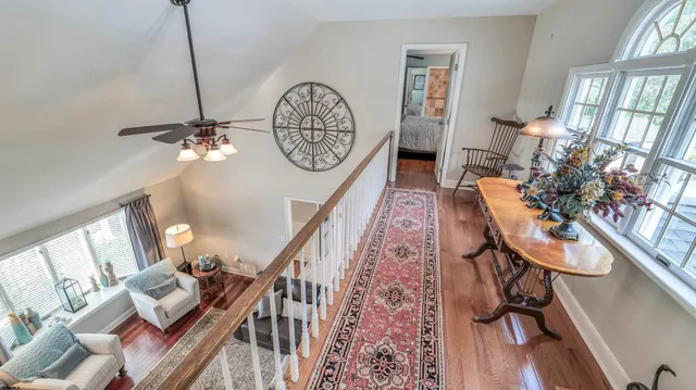 a living room with furniture ceiling fan and a large window