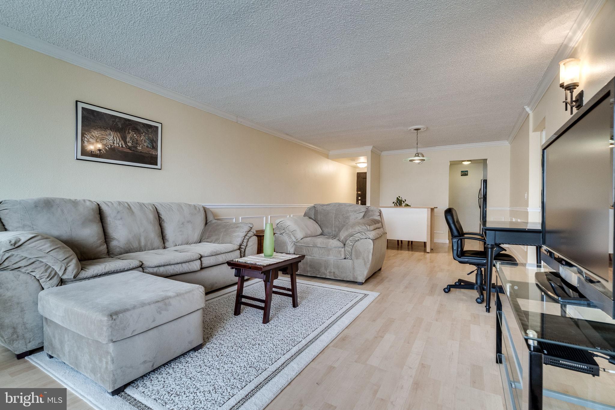 6101 Edsall Road, Unit 905 Alexandria, VA 22304 - Photo 13 of 62 a living room with furniture a flat screen tv and a table
