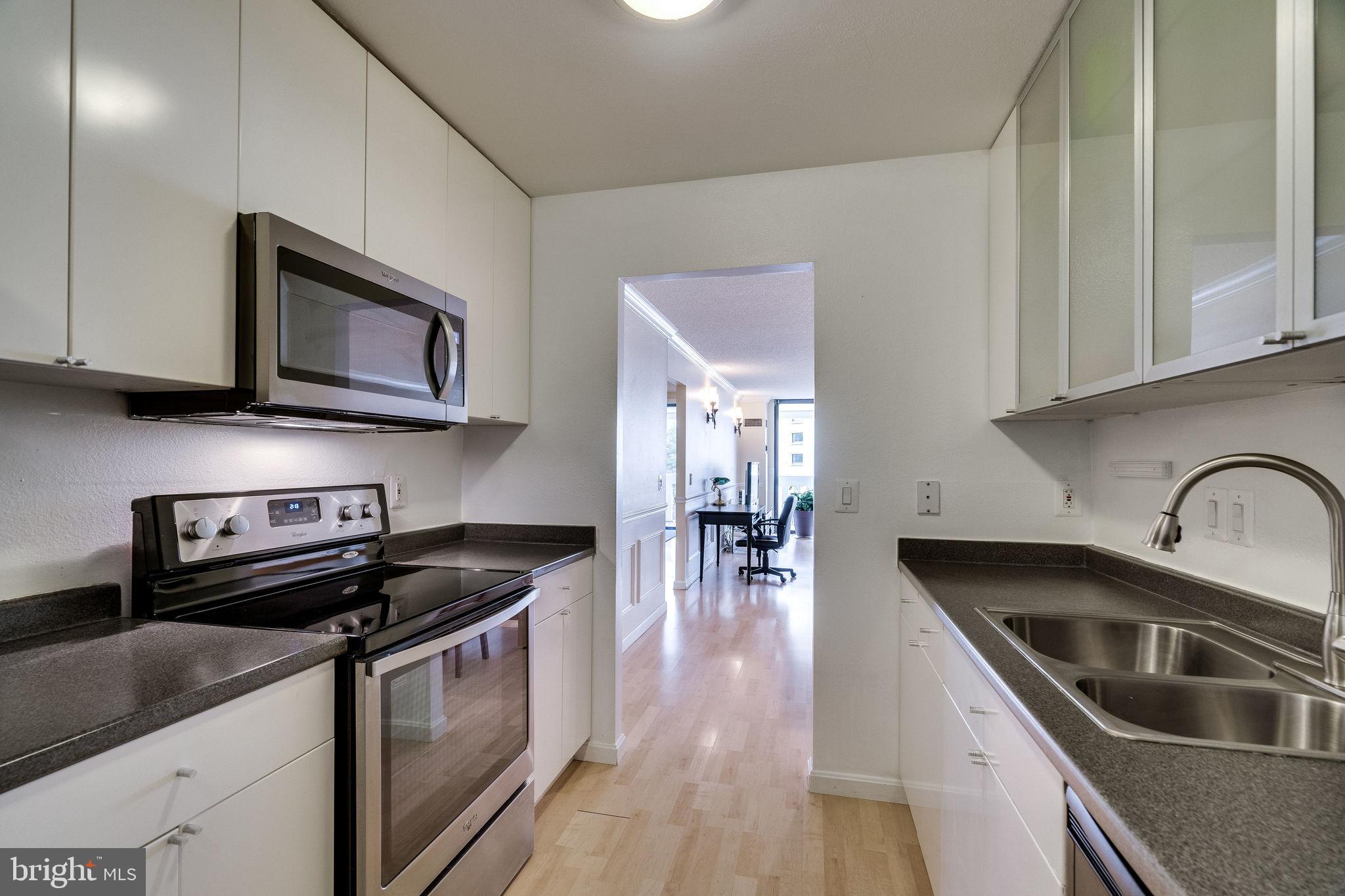 6101 Edsall Road, Unit 905 Alexandria, VA 22304 - Photo 25 of 62 a kitchen with granite countertop a stove a sink a microwave and cabinets