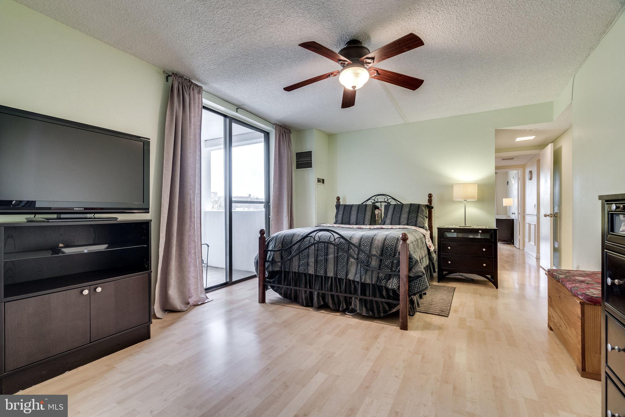 6101 Edsall Road, Unit 905 Alexandria, VA 22304 - Photo 28 of 62 a spacious bedroom with a bed and a chandelier