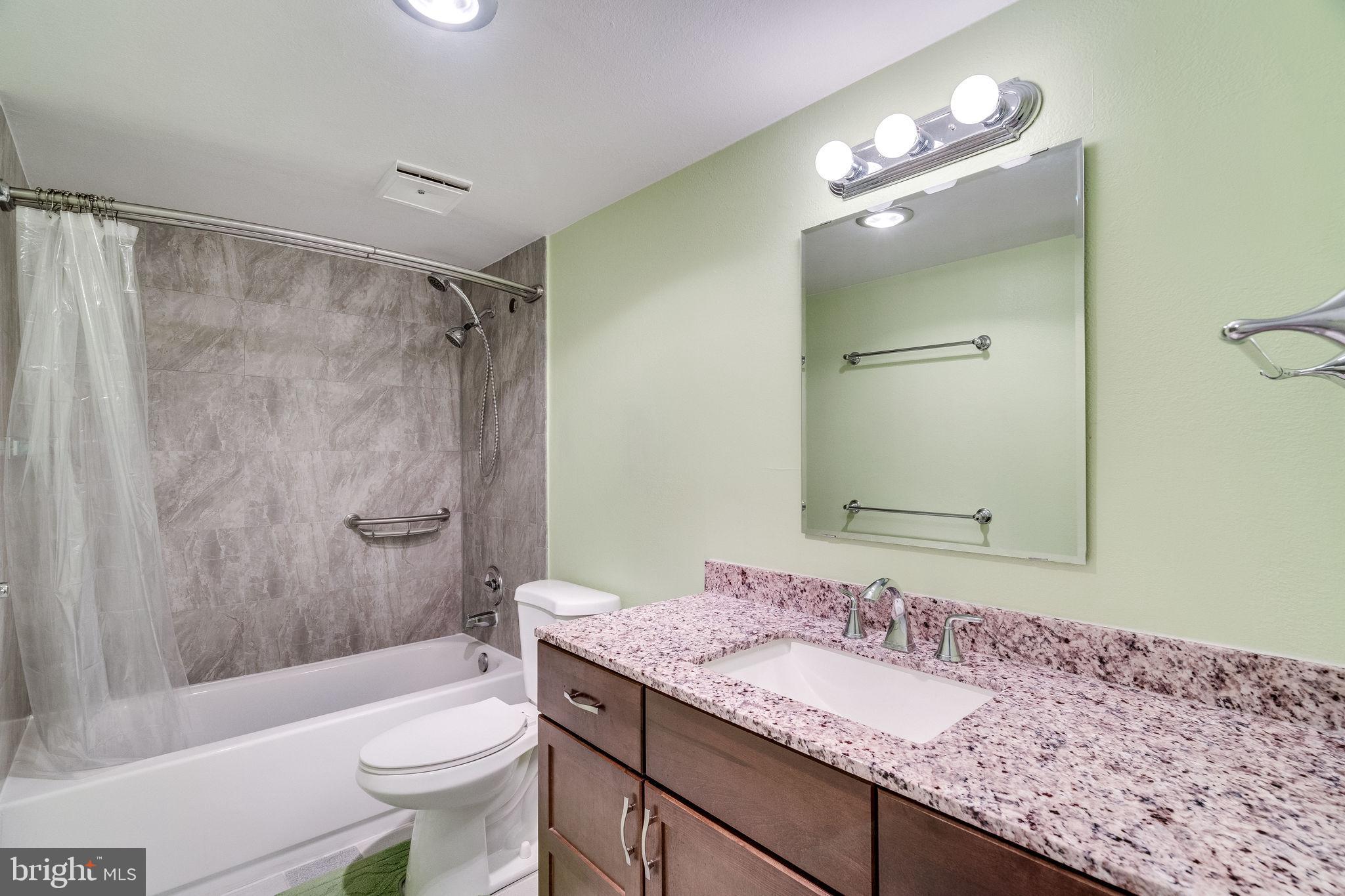 6101 Edsall Road, Unit 905 Alexandria, VA 22304 - Photo 33 of 62 a bathroom with a granite countertop sink toilet mirror and shower