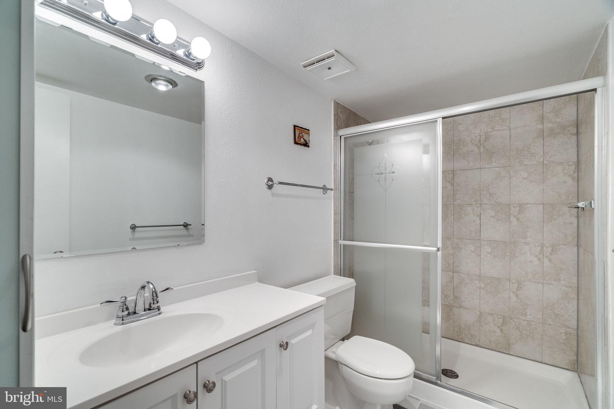 6101 Edsall Road, Unit 905 Alexandria, VA 22304 - Photo 40 of 62 a bathroom with a sink toilet a mirror and shower