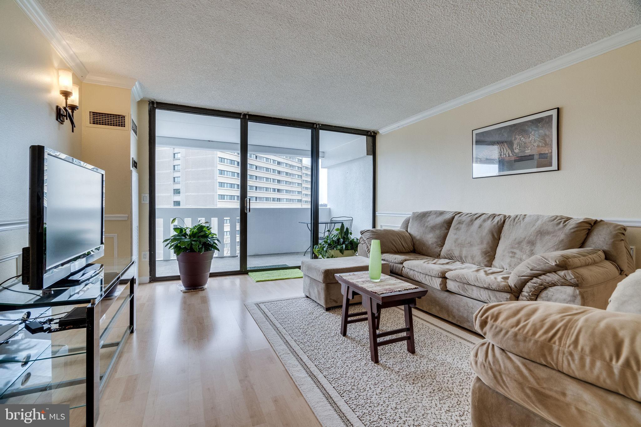 6101 Edsall Road, Unit 905 Alexandria, VA 22304 - Photo 6 of 62 a living room with furniture and a flat screen tv