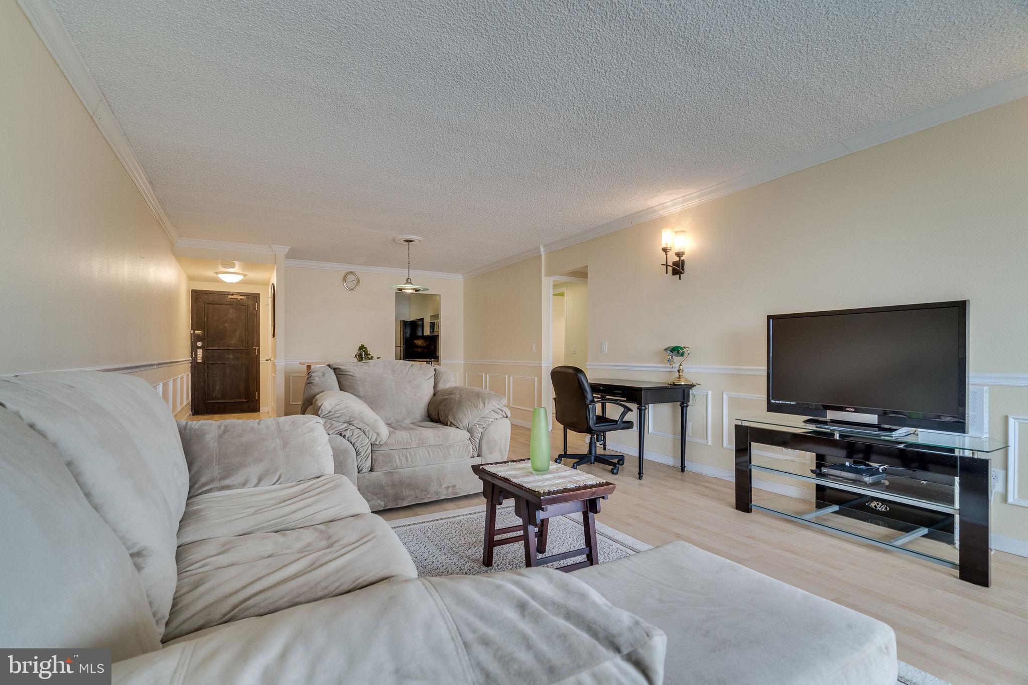 6101 Edsall Road, Unit 905 Alexandria, VA 22304 - Photo 10 of 62 a living room with furniture and a flat screen tv