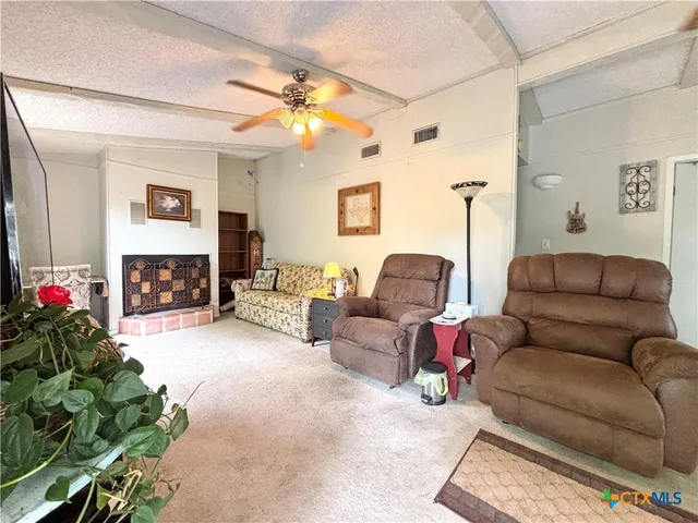 a living room with furniture a fireplace and a chandelier