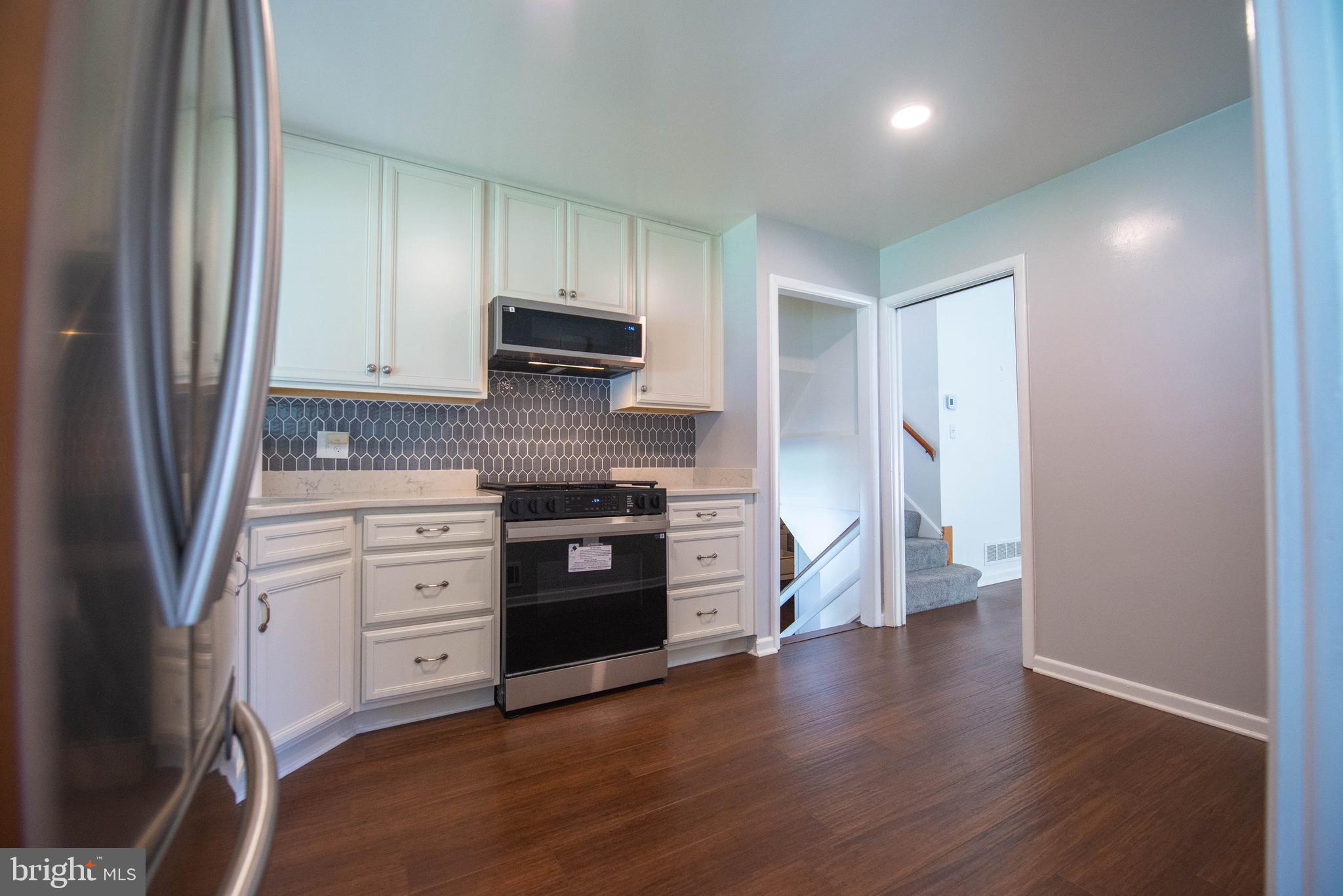7408 Shirley Road Baltimore, MD 21207 - Photo 2 of 25 a kitchen with granite countertop a refrigerator stove and sink
