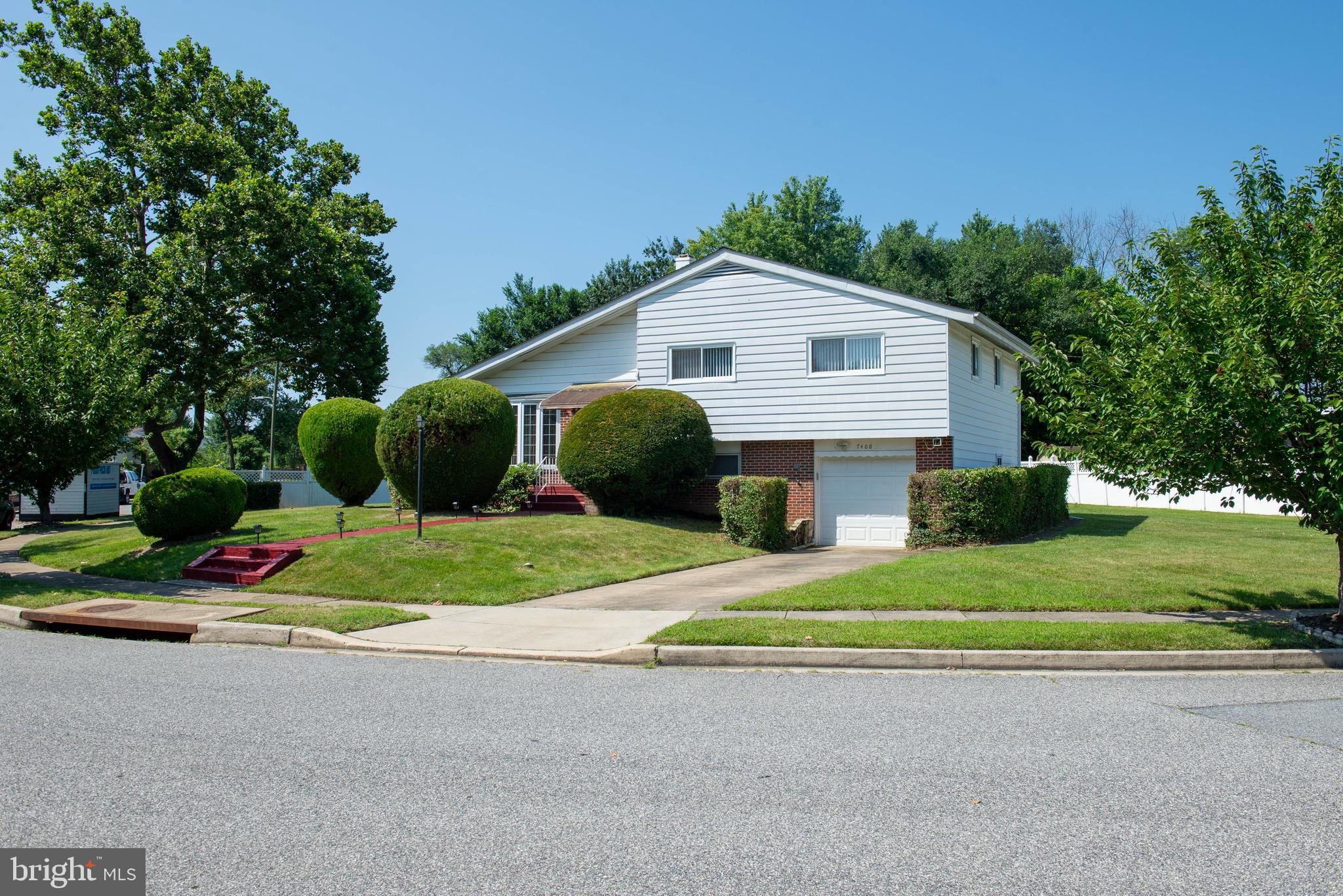 7408 Shirley Road Baltimore, MD 21207 - Photo 22 of 25 a front view of a house with a yard and garage