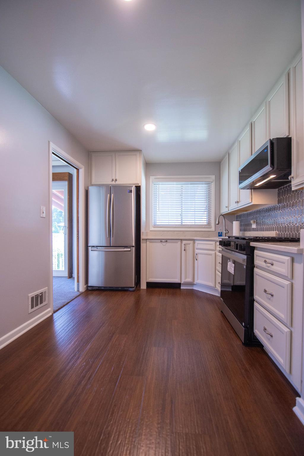 7408 Shirley Road Baltimore, MD 21207 - Photo 3 of 25 a view of a kitchen with wooden floor and electronic appliances