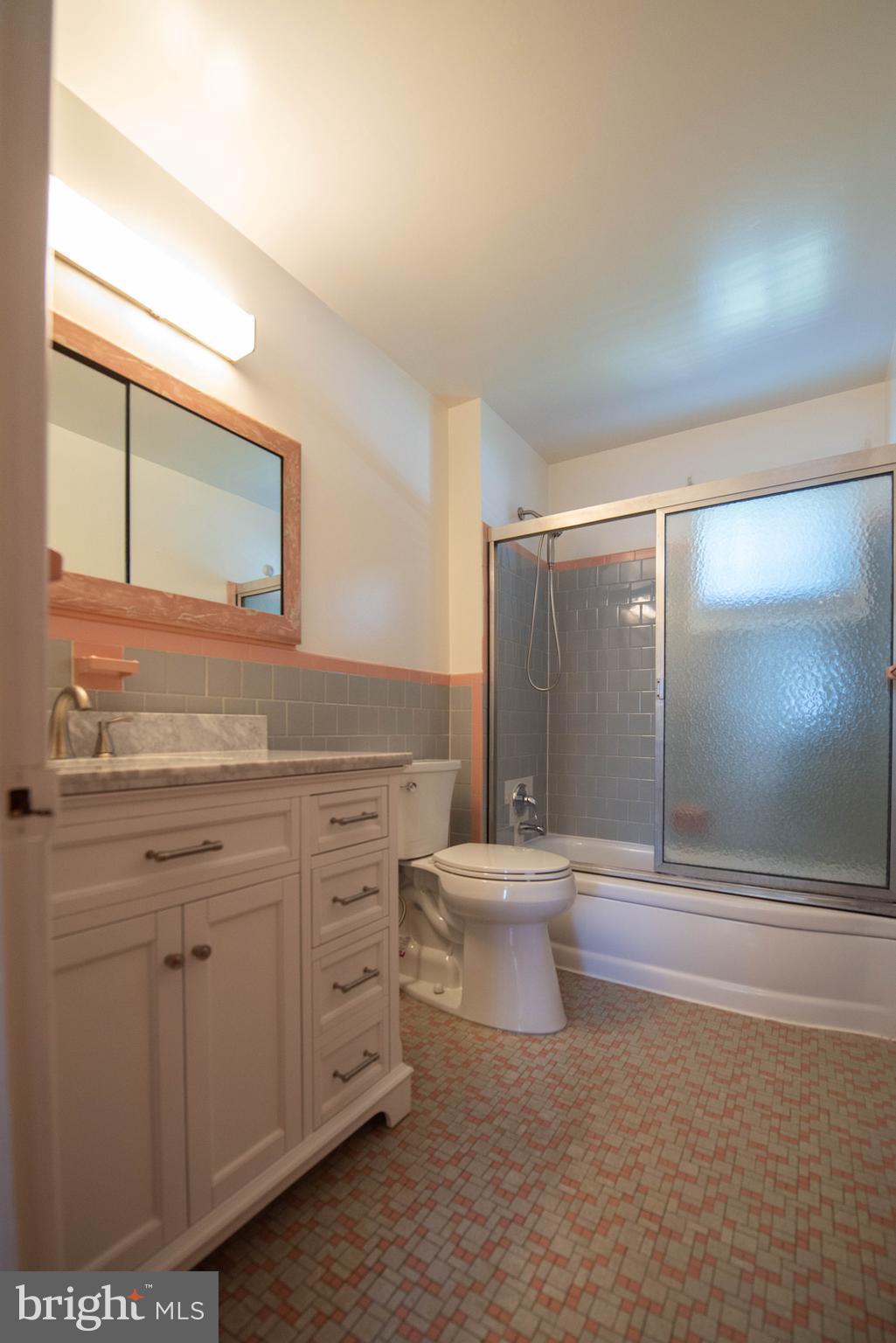 7408 Shirley Road Baltimore, MD 21207 - Photo 7 of 25 a bathroom with a sink a toilet and mirror