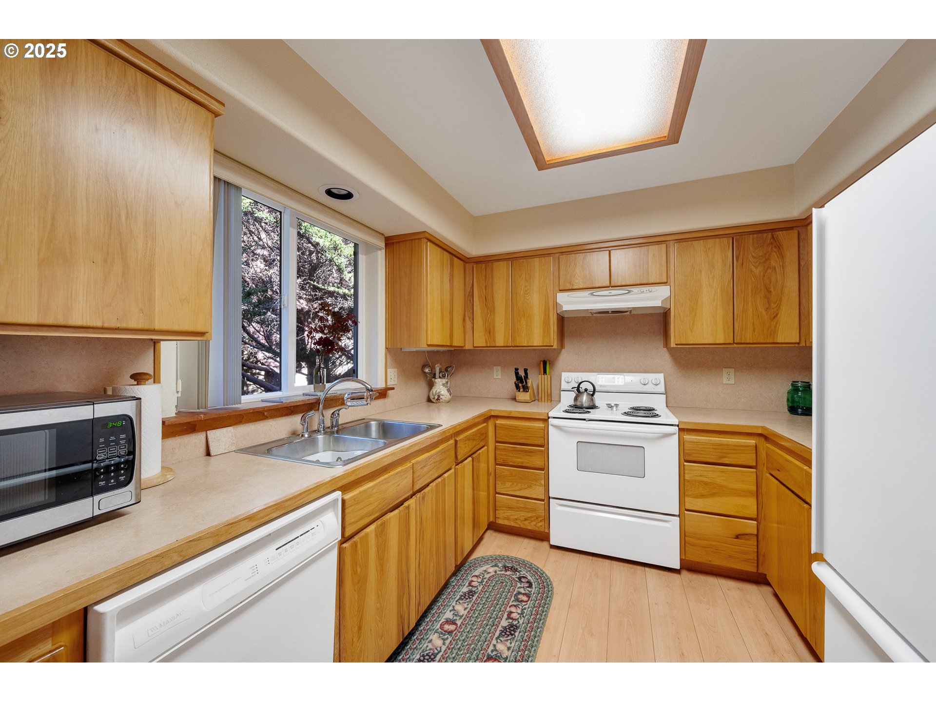 10750 Neptune Way Nehalem, OR 97131 - Photo 10 of 25 a kitchen with a stove a sink and a microwave