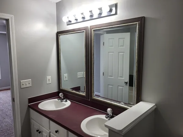 a bathroom with a sink vanity granite and a mirror