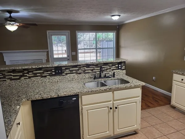 a kitchen with granite countertop white cabinets and white appliances