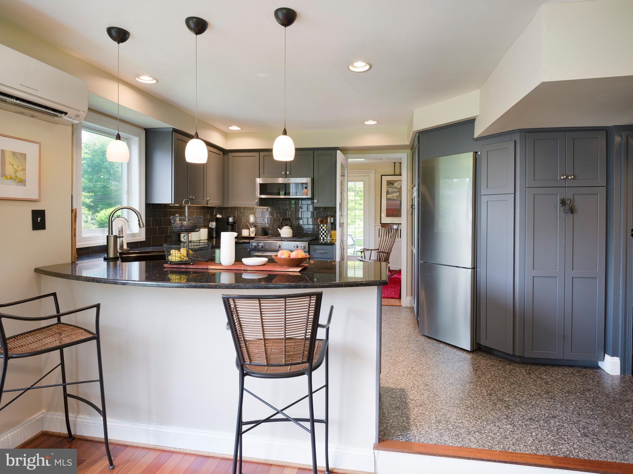 442 Old Eagle School Road Wayne, PA 19087 - Photo 13 of 39 a kitchen with stainless steel appliances a dining table chairs and a refrigerator