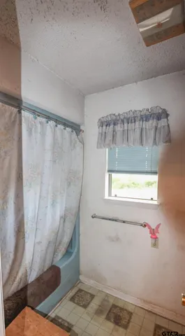 a bathroom with a window and a shower