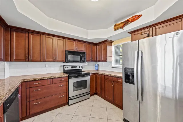 a kitchen with stainless steel appliances granite countertop a refrigerator and a stove top oven