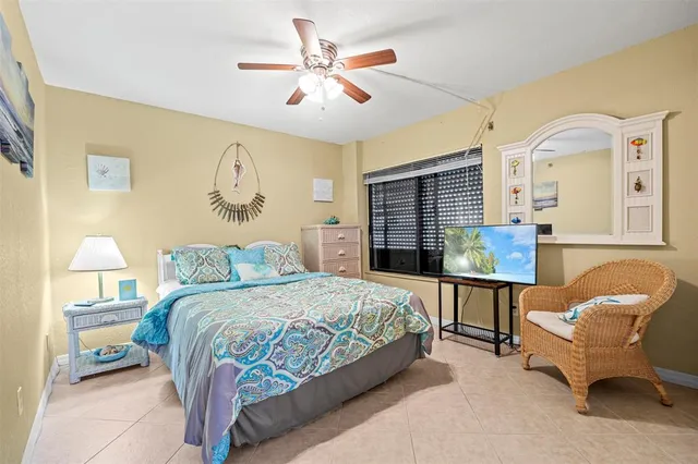 a bedroom with a bed a couch and a chandelier