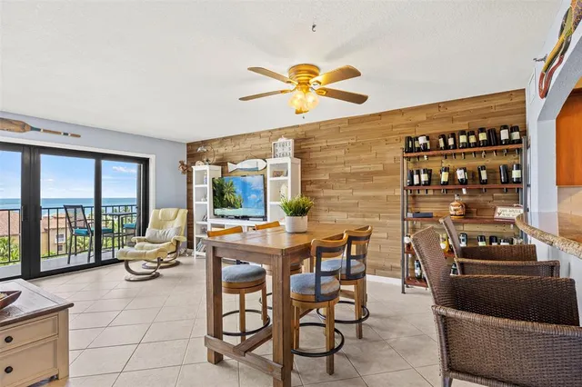 a dining room with furniture and a floor to ceiling window