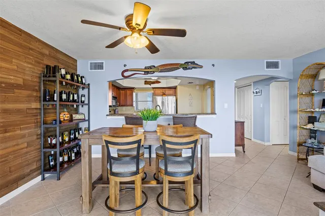 a dining room with furniture and chandelier fan