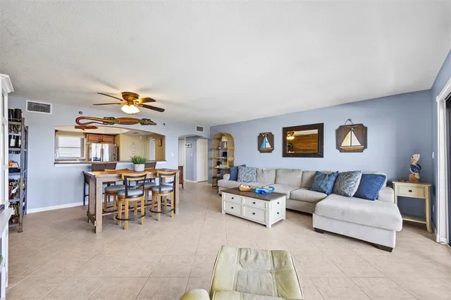 a living room with furniture and a dining table with chairs