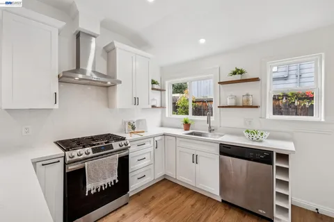 a kitchen with stainless steel appliances granite countertop a stove a sink and a wooden floors