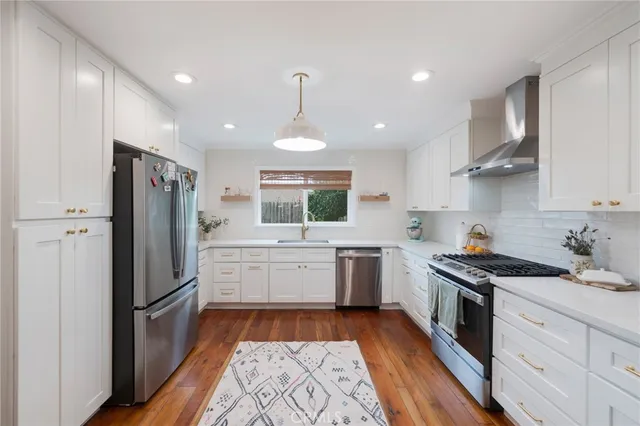 a kitchen with a refrigerator a sink and cabinets