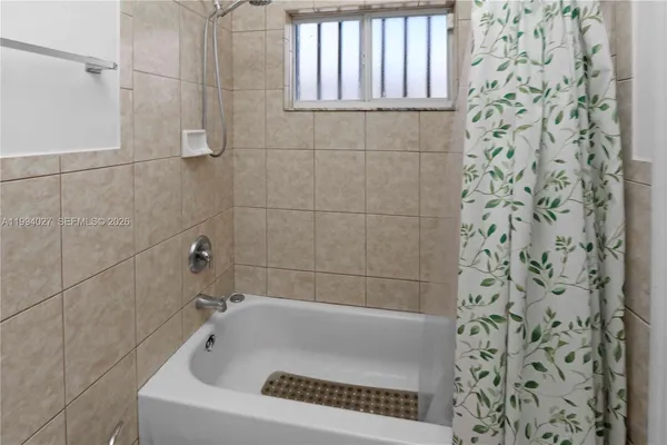 a white bath tub sitting next to a shower