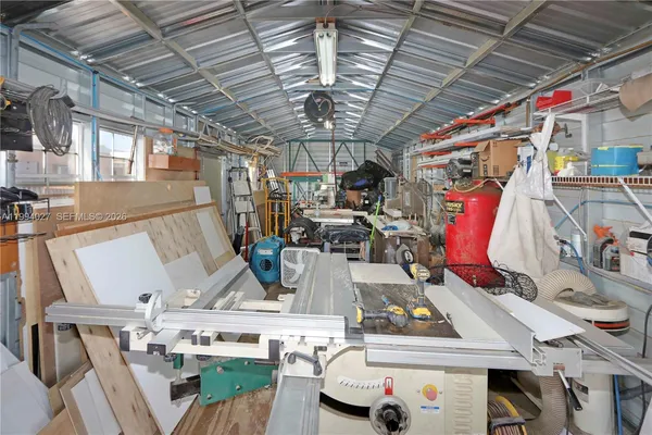 an aerial view of a house with swimming pool and large trees