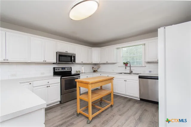 a kitchen with white cabinets and white appliances