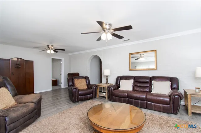 a living room with furniture a ceiling fan and a rug