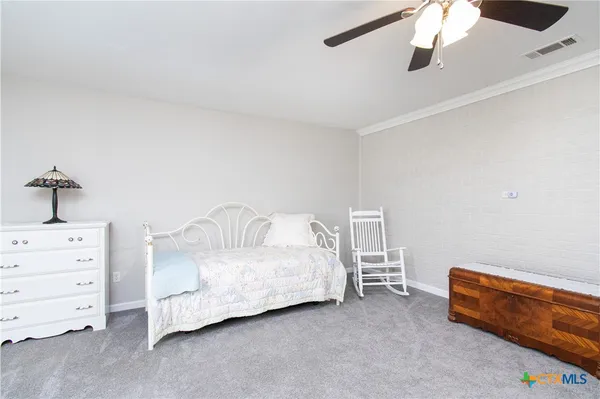 a spacious bedroom with a bed and a dresser