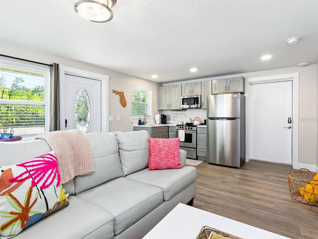 544 Canal Road Sarasota, FL 34242 - Photo 3 of 35 a living room with furniture wooden floor and a refrigerator