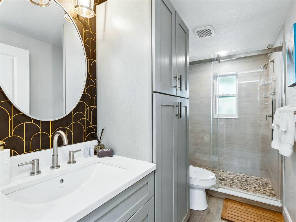 544 Canal Road Sarasota, FL 34242 - Photo 10 of 35 a bathroom with a sink toilet a mirror and shower