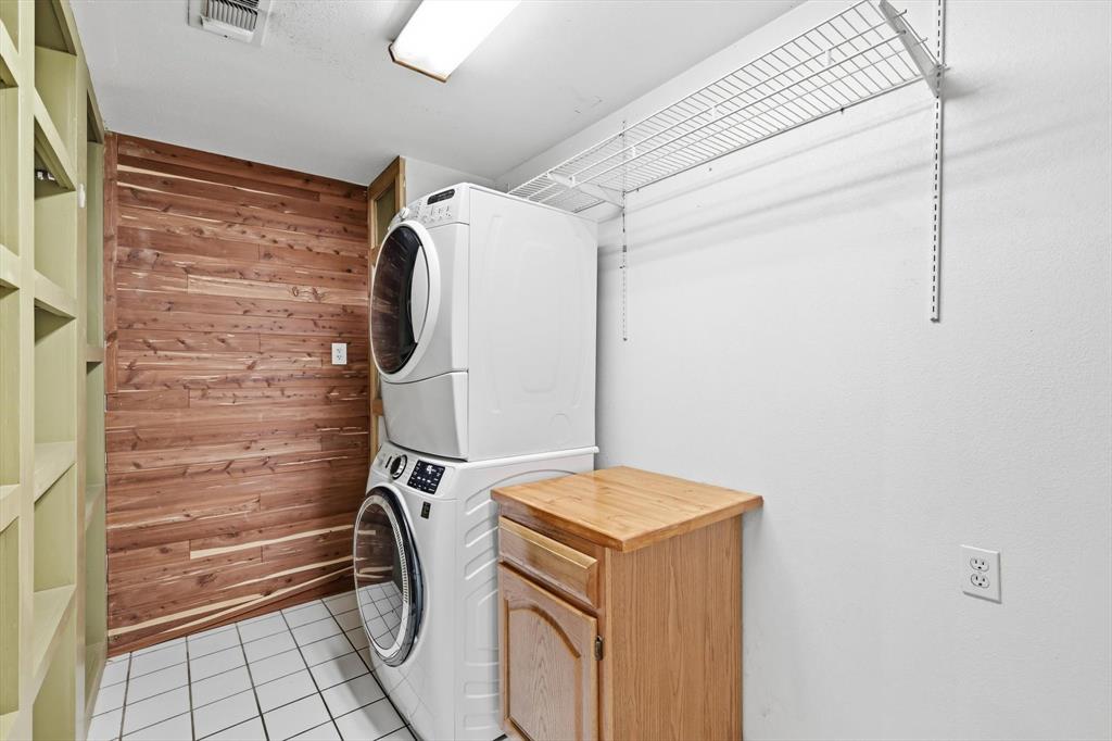 123 Valley Ranch Road Sherman, TX 75092 - Photo 29 of 40 Laundry area featuring wooden walls, stacked washer / drying machine, and light tile patterned floors