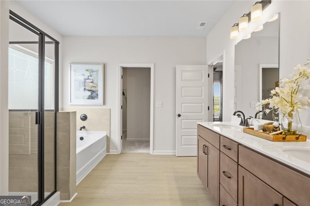 156 Saddle Ridge Trail Calhoun, GA 30701 - Photo 35 of 45 a spacious bathroom with a double vanity sink a mirror and a bathtub