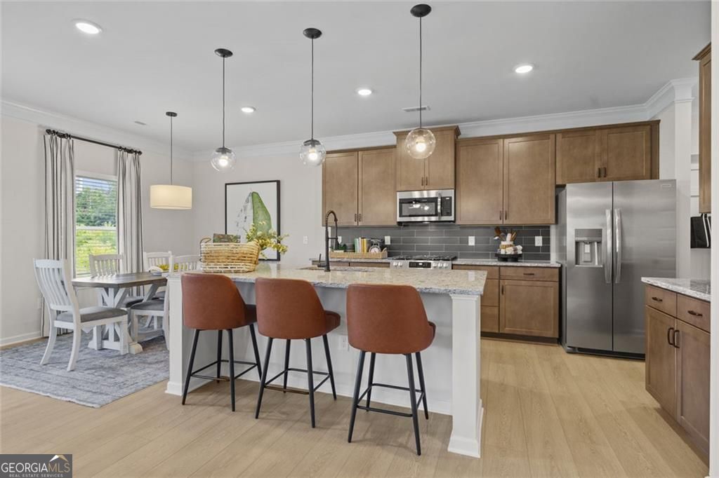 156 Saddle Ridge Trail Calhoun, GA 30701 - Photo 8 of 45 a kitchen with stainless steel appliances granite countertop a refrigerator a stove a sink dishwasher a dining table and chairs with wooden floor