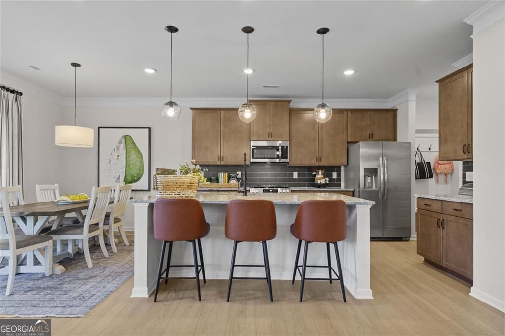 156 Saddle Ridge Trail Calhoun, GA 30701 - Photo 9 of 45 a kitchen with stainless steel appliances granite countertop a stove a refrigerator a kitchen island a dining table and chairs