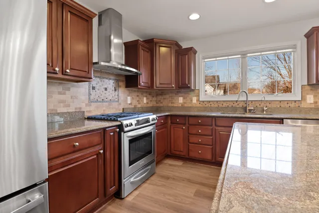 a kitchen with stainless steel appliances granite countertop a stove a sink and a microwave