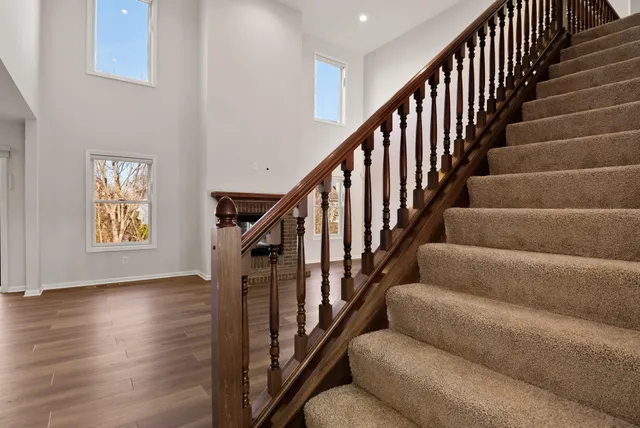 a view of a livingroom with furniture wooden floor and staircase
