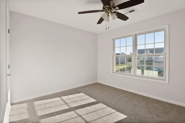 an empty room with a window and a fan