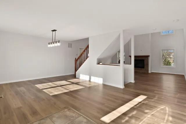 a view of empty room with wooden floor and fireplace