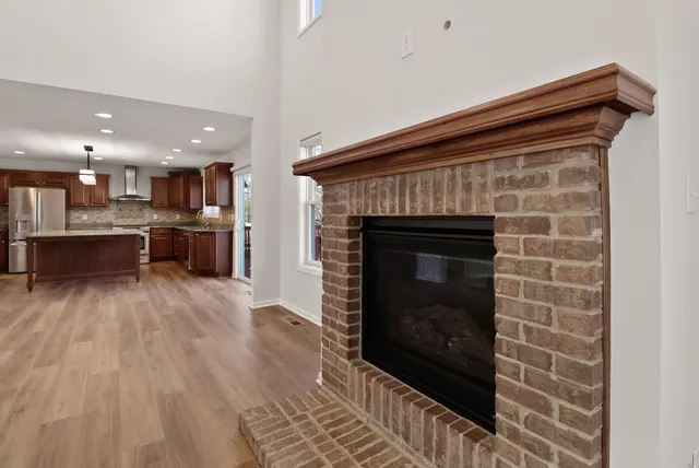 a open kitchen view with fireplace and window