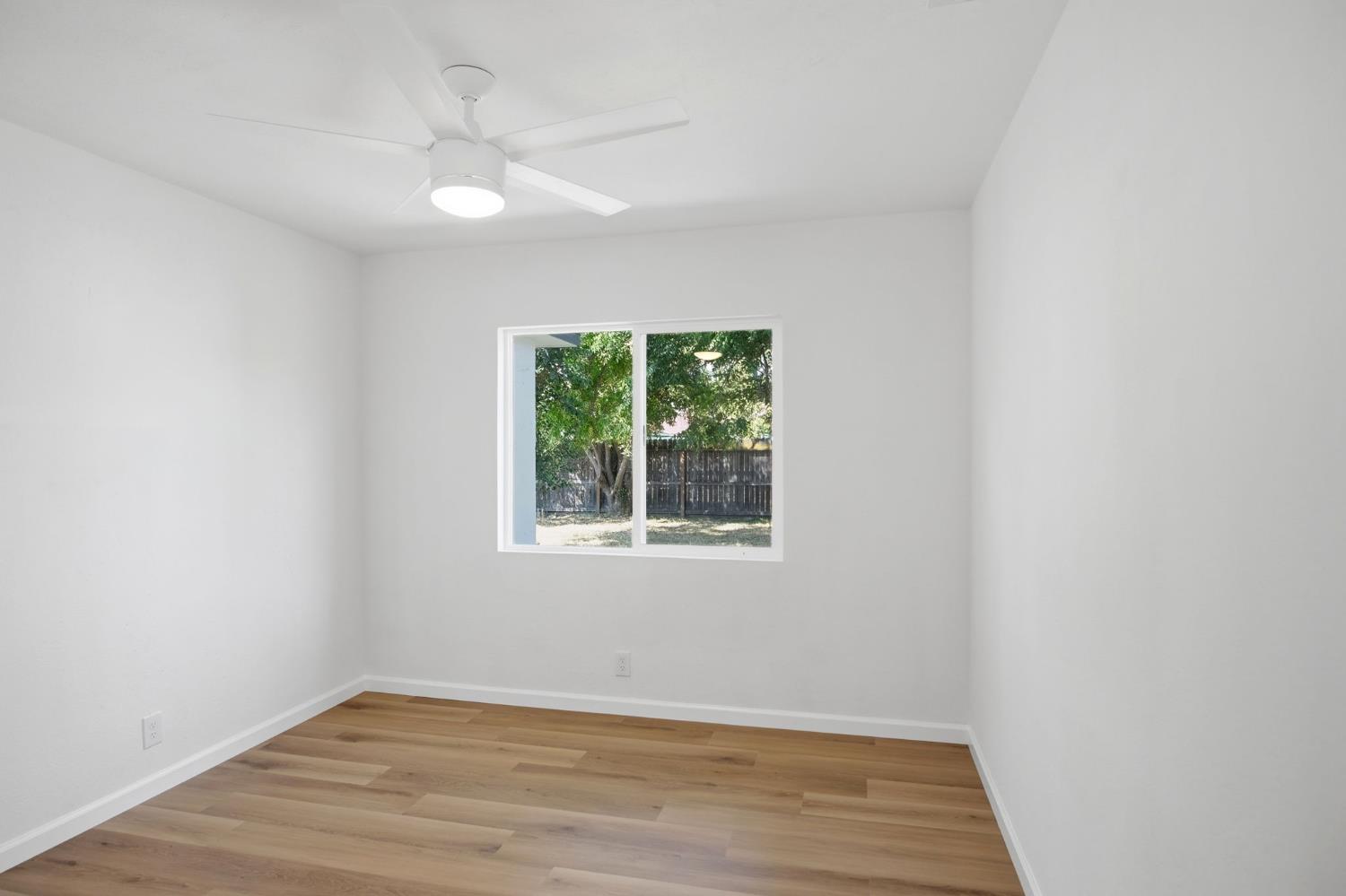 1451 Kent Way Modesto, CA 95355 - Photo 19 of 37 an empty room with wooden floor and windows